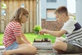 Happy children playing chess on backyard at sunny day while summer holidays Royalty Free Stock Photo