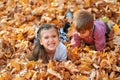 Happy children playing, posing, smiling and having fun in autumn city park. Bright yellow trees and leaves Royalty Free Stock Photo