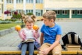 Happy children playing in the school yard at the day time.School breakfast, fruits and juice. Stack of textbooks, books. Concept Royalty Free Stock Photo