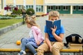 Happy children playing in the school yard at the day time.School breakfast, fruits and juice. Stack of textbooks, books. Concept Royalty Free Stock Photo