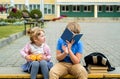 Happy children playing in the school yard at the day time.School breakfast, fruits and juice. Stack of textbooks, books. Concept Royalty Free Stock Photo