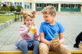 Happy children playing in the school yard at the day time.School breakfast, fruits and juice. Stack of textbooks, books. Concept Royalty Free Stock Photo