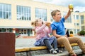 Happy children playing in the school yard at the day time.School breakfast, fruits and juice. Stack of textbooks, books Royalty Free Stock Photo