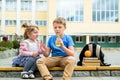 Happy children playing in the school yard at the day time.School breakfast, fruits and juice. Stack of textbooks, books. Concept Royalty Free Stock Photo