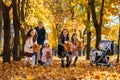 happy children playing together and scattering yellow leaves, portrait of big family in autumn city park, children running with