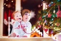 Happy children playing under a beautiful Christmas tree Royalty Free Stock Photo