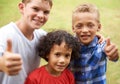 Happy children, portrait and thumbs up for outdoor teamwork, winning or good job together in nature. Group of casual Royalty Free Stock Photo