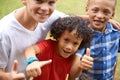 Happy children, portrait and thumbs up at park for teamwork, winning or good job together in nature. Group of casual Royalty Free Stock Photo