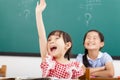 Happy children raised hands in class