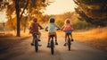 Happy children riding bikes at sunset in the park. Kids having fun outdoors. Royalty Free Stock Photo