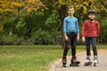 Happy children roller skating in autumn park Royalty Free Stock Photo