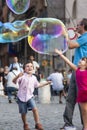 Happy children running towards a soap bubble