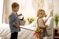 Happy children, siblings, enjoying Easter holiday together, tradition with handmade twig, braided whip made from pussy willow