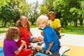 Happy children sitting on playground carousel