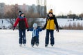 Happy children, skating on a frozen lake in the park