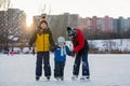 Happy children, skating on a frozen lake in the park