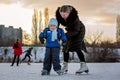 Happy children, skating on a frozen lake in the park