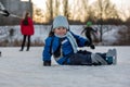 Happy children, skating on a frozen lake in the park