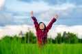 Happy children rise hand up to sky and smile in rice field of organic farmland