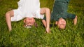 Happy children standing upside down on green grass Royalty Free Stock Photo