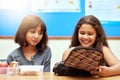 Happy children, students and eating lunch in classroom at school for meal, break or snack time. Young little girls or Royalty Free Stock Photo