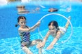 Happy children swim in pool underwater, girls swimming