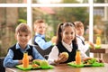 Happy children at table healthy food in school canteen