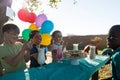 Happy children talking while having food and drinks against sky at table Royalty Free Stock Photo