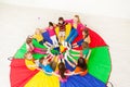 Happy children and teacher sitting on parachute Royalty Free Stock Photo