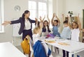 Happy children and their female teacher having fun together during lesson in school classroom. Royalty Free Stock Photo