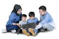 Happy children using a laptop with their parents Royalty Free Stock Photo