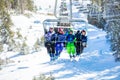 Happy children wave hands sitting on the chairlift Royalty Free Stock Photo