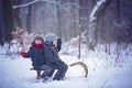 Happy children in a winter park, playing together with a sledge Royalty Free Stock Photo