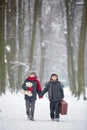 Happy children in a winter park, playing together with a sledge Royalty Free Stock Photo