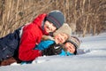 Happy children in winterwear playing in snowdrift Royalty Free Stock Photo