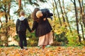 Happy children with young mother playing together. Fashionable family walking in autumn park. Autumn fashion, lifestyle Royalty Free Stock Photo