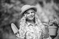 Happy childrens day. Child in hat with shoulder blade small shovel hoe. Happy smiling gardener girl. Happy childhood Royalty Free Stock Photo