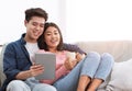 Happy Chinese Couple Using Digital Tablet Relaxing At Home Royalty Free Stock Photo