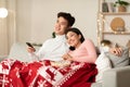 Happy Chinese Couple Watching TV On Christmas Eve At Home Royalty Free Stock Photo