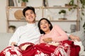 Happy Chinese Couple Watching TV Sitting On Couch At Home Royalty Free Stock Photo