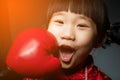 Happy chinese girl getting a hard punch from boxing glove fist. Royalty Free Stock Photo