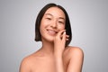 Happy Chinese lady enjoying skin softness