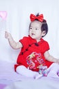 Happy Chinese little baby in red cheongsam have fun