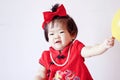 Happy Chinese little baby in red cheongsam play yellow balloon Royalty Free Stock Photo