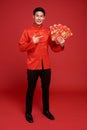 Happy Chinese new year. Asian man holding angpao or red packet monetary gift isolated on red background. text means great luck