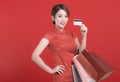 Happy chinese new year. Asian young Woman showing credit card  and holding  the shopping bags Royalty Free Stock Photo
