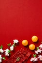 Happy Chinese New Year 2023 composition. Flat lay tangerines, blossom flowers, money packets on red background Royalty Free Stock Photo