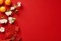 Happy Chinese New Year flat lay composition. Red envelope packets, orange mandarins, Chinese blossom flowers on red background Royalty Free Stock Photo