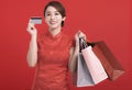 Happy chinese new year. Happy young Woman showing credit card  and holding  the shopping bags Royalty Free Stock Photo