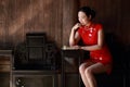 Happy Chinese woman in red cheongsam read book